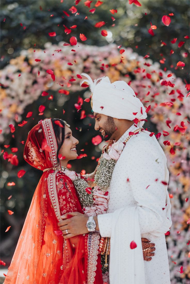 red lehenga bride, white sherwani groom, flower…